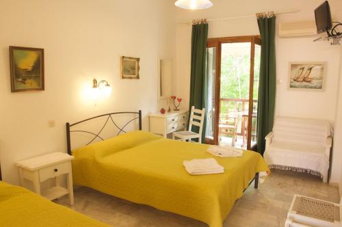 sypialnia z 2 łóżkami i drzwiami na balkon w obiekcie Mirto Apartments w mieście Afissos