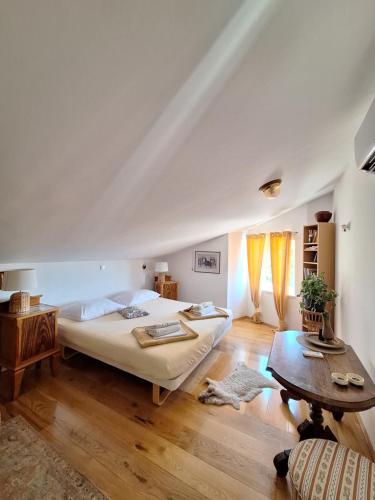 ein Schlafzimmer mit einem großen Bett und einem Tisch in der Unterkunft Villa Darije in Novalja