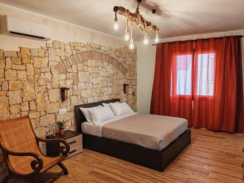 a bedroom with a bed and a brick wall at S'Arrioleddu in Muravera