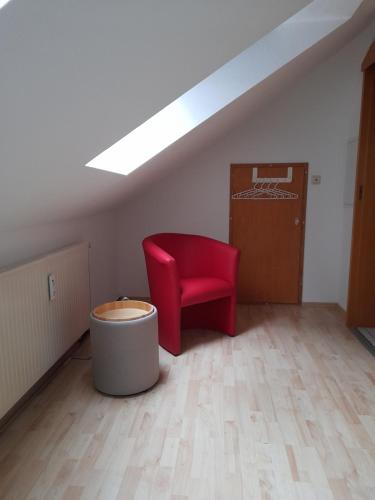 a room with a red chair in a attic at Casa Tina in Homberg