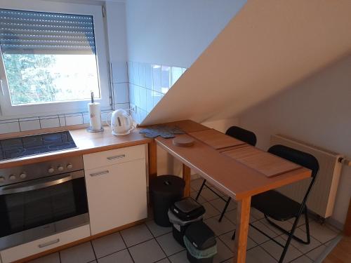 a small kitchen with a wooden table and a stove at Casa Tina in Homberg