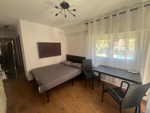 a room with a bed and a desk and a window at Apartamento Salou 2 playas, 2 km PortAventuraWorld in Salou