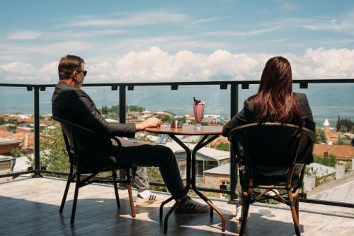 a man and woman sitting at a table on a balcony at Boutique Hotel Kviria in Tʼelavi