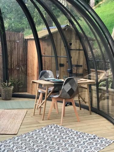 une table et des chaises en bois sur une terrasse dans l'établissement Dôme de la bergerie, à Saint-Valery-en-Caux