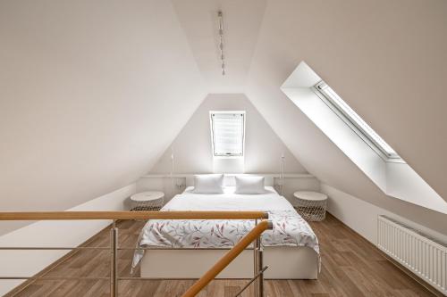 a white room with a bed in a attic at Villa Matylda in Mariánské Lázně