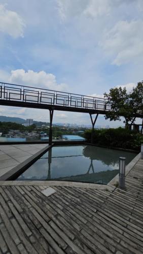 a bridge over a pool of water with a bridge over it at Urban 360 Batu Caves Sri Gombak Selayang Wifi Netflix by N&N in Batu Caves