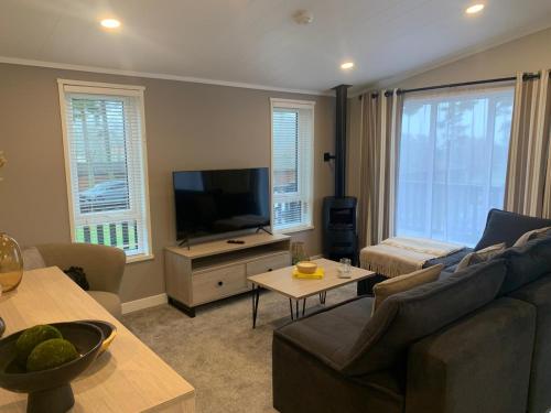a living room with a couch and a flat screen tv at 30 Golf View in Jedburgh