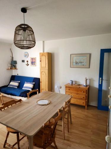 un salon avec une table et un canapé bleu dans l'établissement Appartement ARCACHON, à Arcachon