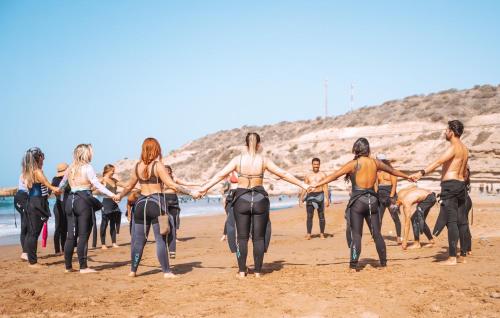 a group of people holding hands on the beach at Cozy Beach Camp in Agadir