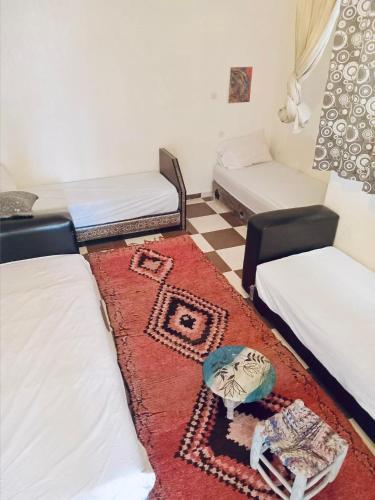 a living room with two beds and a rug at Cozy Beach Camp in Agadir