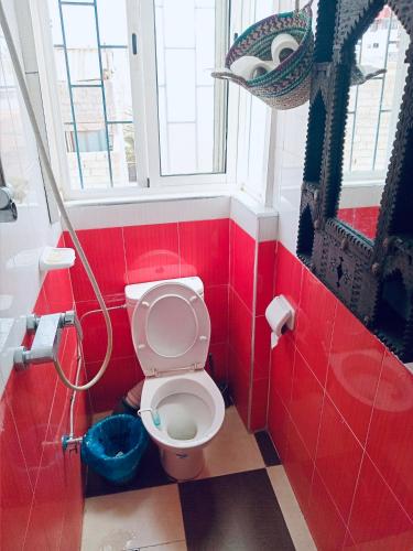 a red bathroom with a toilet and a window at Cozy Beach Camp in Agadir