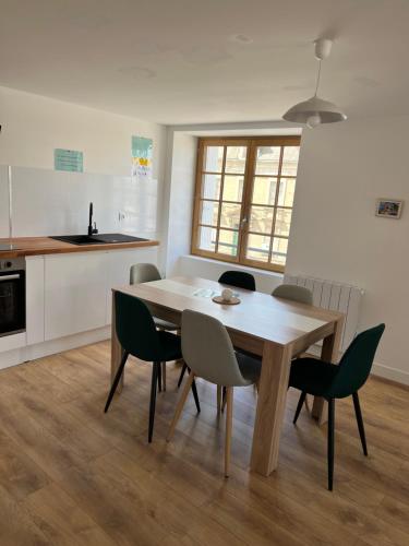 une cuisine et une salle à manger avec une table et des chaises dans l'établissement L'appartement des Perroquets, à Châteaubriant
