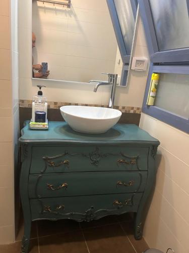 a bathroom with a sink on top of a green dresser at The Turquoise Suite on the Sea Trail, Atlit in Atlit