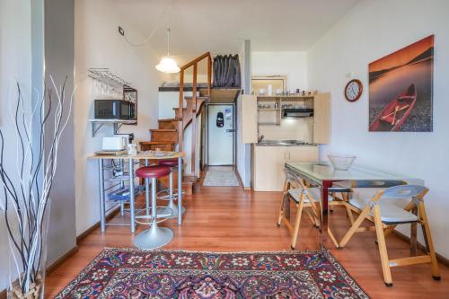 a living room with a table and a kitchen at Garda Panoramic House in Albisano