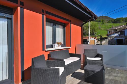 a patio with three chairs and a window at Apartamentos La Cueva - Onis in Avín