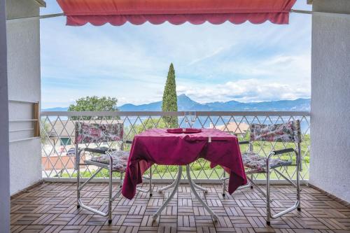 a table with a purple table cloth sitting on a balcony at Garda Panoramic House in Albisano