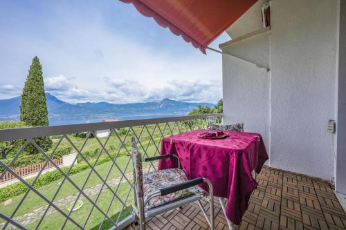 a table with a purple table cloth on a balcony at Garda Panoramic House in Albisano