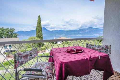 a table with a pink table cloth on a balcony at Garda Panoramic House in Albisano