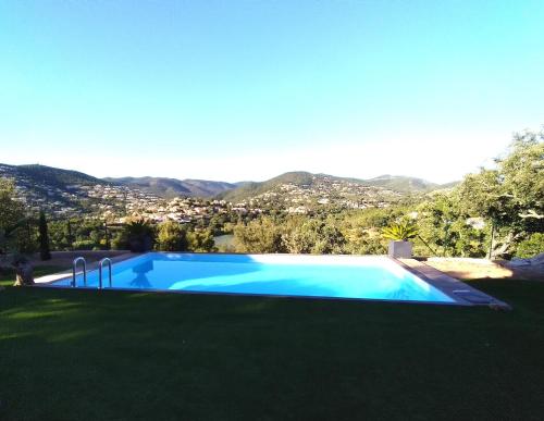 - une piscine dans une cour avec des montagnes en arrière-plan dans l'établissement Superbe bas de villa 80 m2 piscine privée réservée aux vacanciers avec vue magnifique 6 couchages, à La Londe-les-Maures