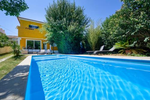 a swimming pool in front of a house at Beach & Nature Villa with Amazing Pool by TimeCooler in Setúbal