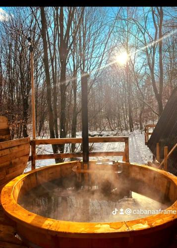 a wooden bath tub with a hot tub at CabanaAframe in Curtea de Argeş