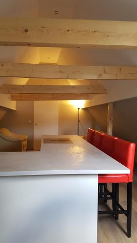 a kitchen with a white table and two red chairs at Neue wunderschöne Ferienwohnung direkt im Herzen von Rockenhausen in Rockenhausen