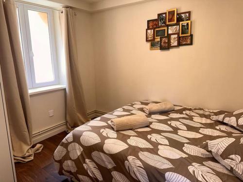 une chambre avec un lit avec une couette et une fenêtre dans l'établissement AG- Le Charme de la Vieille Ville pour 4 personnes, à Villeneuve-Loubet