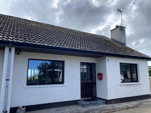 a white house with a chimney on top of it at Eileen's Cottage in Castlerock