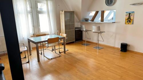 une salle à manger avec une table et des chaises en verre dans l'établissement Citywohnung in ruhiger Innenstadtnähe von Coburg, à Cobourg
