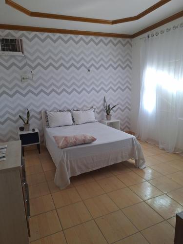 a bedroom with a bed and a wall at Quarto triplo com banheiro em Pousada e Restaurante in Manaus