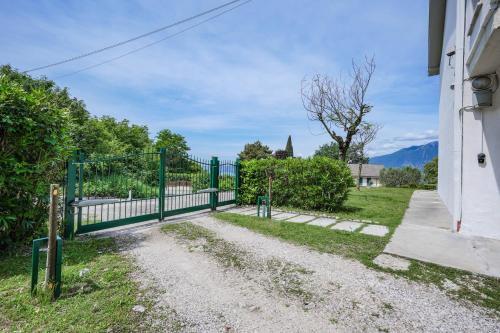 a green fence in front of a house at Garda Panoramic House in Albisano