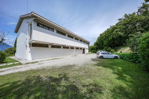 a white house with a car parked in the driveway at Garda Panoramic House in Albisano