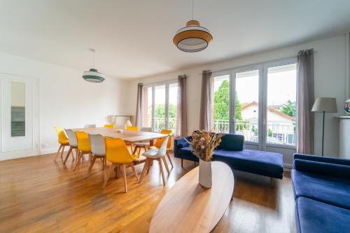 un salon avec une table et des chaises jaunes dans l'établissement Villa Foch, à Aulnay-sous-Bois