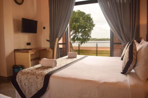 a bedroom with a large bed with a large window at Abhaya Mandapa in Anuradhapura