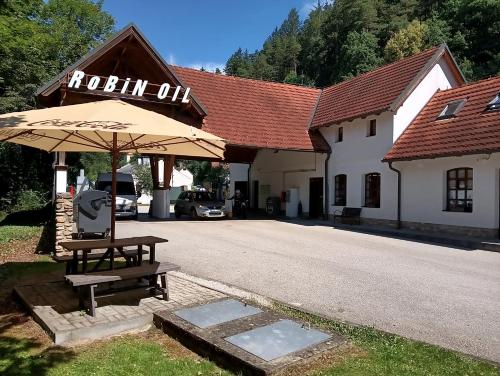 a table with an umbrella in front of a building at Apartmán Rožmberský sen in Rožmberk nad Vltavou