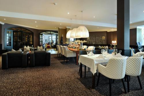 a restaurant with tables and chairs and a dining room at Van der Valk Hotel Nazareth-Gent in Nazareth
