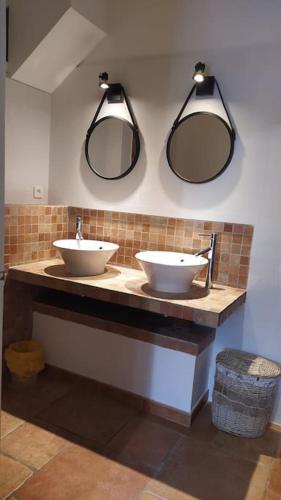 une salle de bain avec deux lavabos et deux miroirs dans l'établissement Appartement T2 entre mer et montagne proche Calvi, à Calenzana