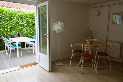 une salle à manger avec une table, des chaises et une porte dans l'établissement Appartement coup de coeur - Terrasse à Biarritz, à Biarritz