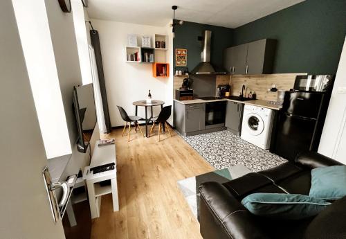 un salon avec un canapé et une cuisine dans l'établissement Appartement Le Grand Large, à Dunkerque