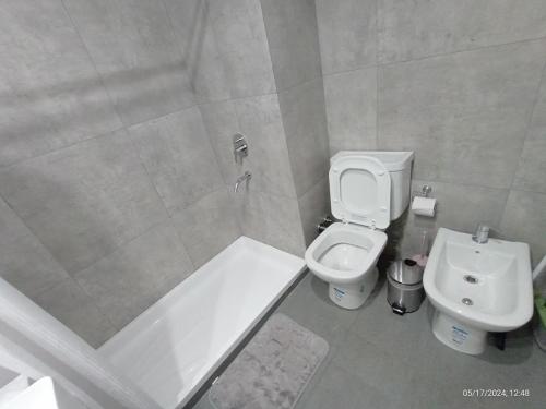a bathroom with a toilet and a tub and a sink at Dolce Apartment in Buenos Aires