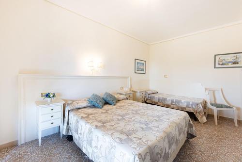 a bedroom with two beds and a dresser and a bed at Villa Capitorsola in Capoliveri