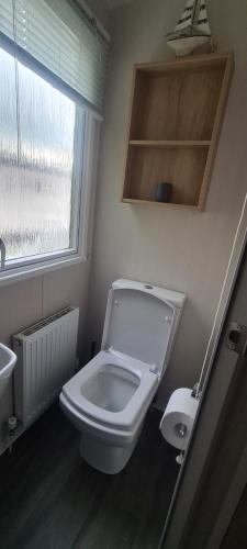 a bathroom with a toilet and a sink and a window at Deluxe 3 Bed Holiday Home in Port Seton in Port Seton