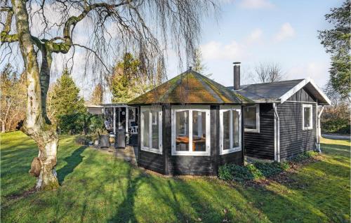 a small house in a yard with a tree at Beautiful Home In Orø With Wifi in Orø