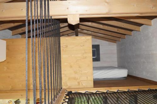 Cette chambre comprend un lit et un plafond en bois. dans l'établissement SPA & Tiny house à la campagne, à La Boissière
