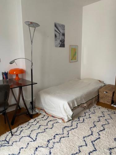 - une chambre avec un lit, une table et un tapis dans l'établissement Charming Apartment Paris Saint Germain Saint Michel, à Paris