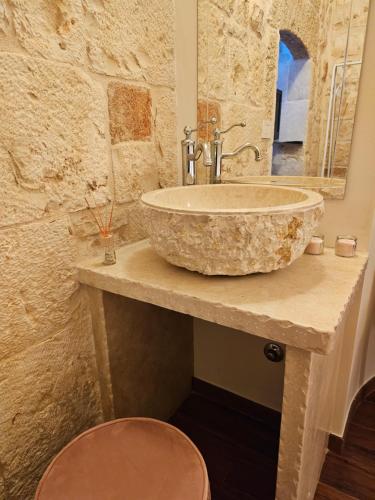 a bathroom with a large stone sink on a counter at PietraRosa Apartment in Triggianello