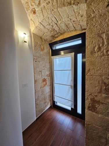 a room with a window and a brick wall at PietraRosa Apartment in Triggianello