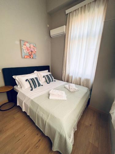 a bedroom with a bed with two towels on it at Aurora Apartments in Mytilini