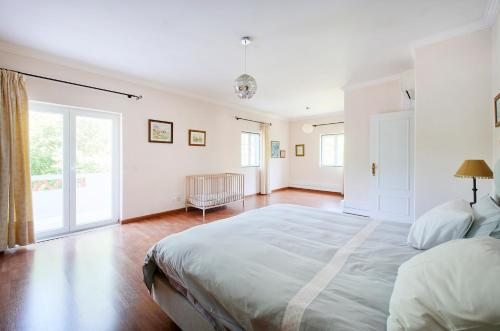 a bedroom with a large bed and a large window at Beach & Nature Villa with Amazing Pool by TimeCooler in Setúbal