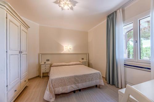a bedroom with a bed and a large window at Villa Capitorsola in Capoliveri
